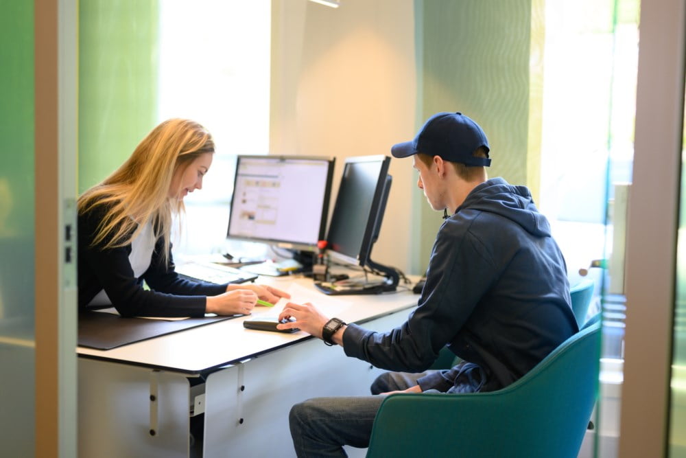 Kunde som får hjelp av en rådgiver i et møte