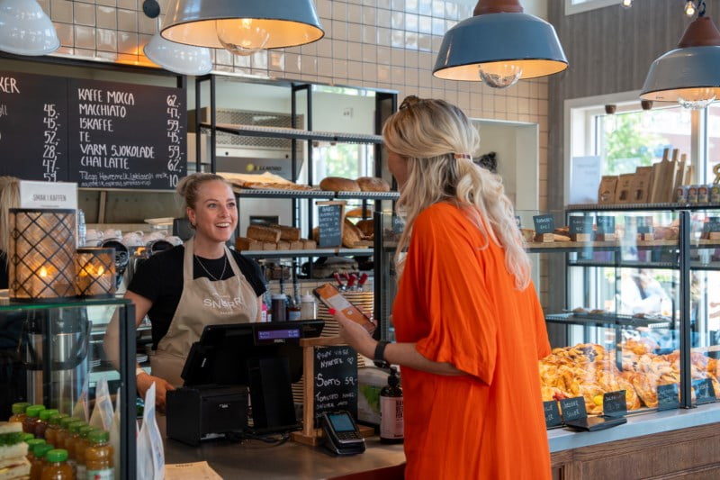 Kari ser på Snurransatt i det hun betaler for kaffe på Snurr