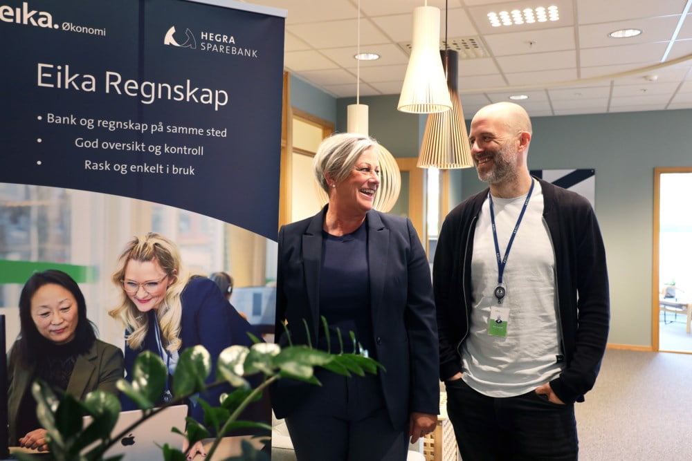 Linn Murry og Einar Svartbekk ser på hverandre mens de smiler. De står inne hos Eika Økonomi Midt-Norge ved siden av en rollup hvor det står Eika Regnskap. En tjeneste både regnskapskontoret Eika Økonomi Midt-Norge og Hegra Sparebank tilbyr sine kunder sammen.